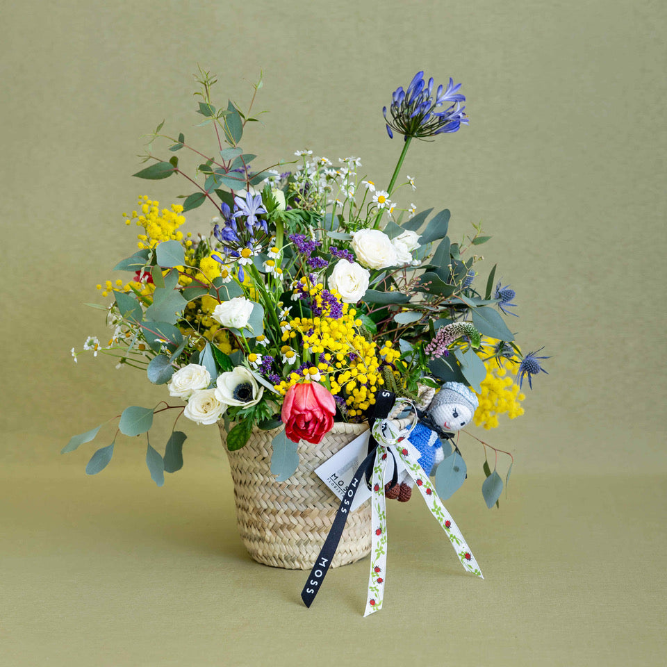 Capazo con flores y muñeco